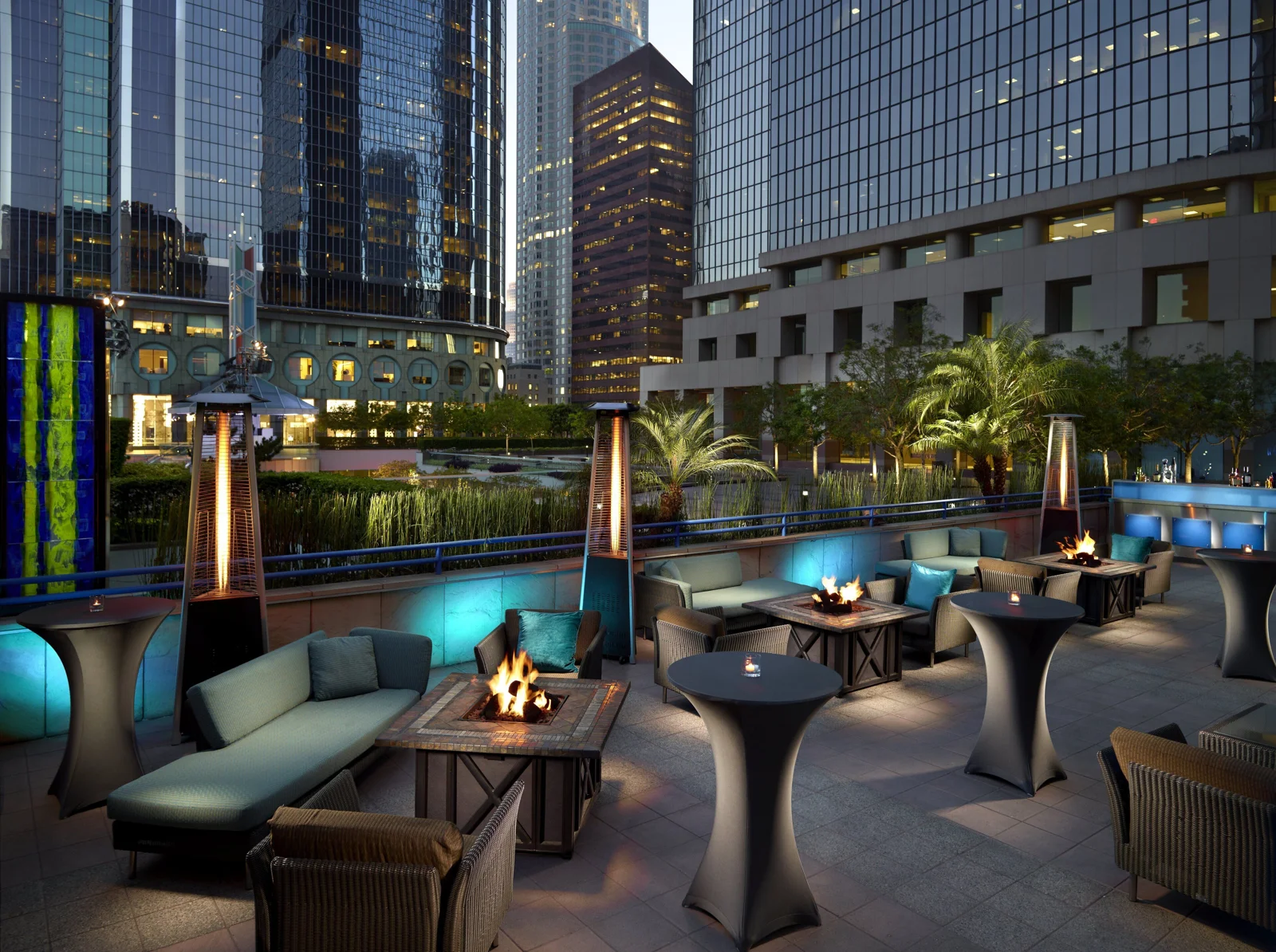 Outdoor lounge with fire pits at night